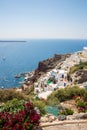 View of Fira town - Santorini island,Crete,Greece. White concrete staircases leading down to beautiful bay with clear blue sky and Royalty Free Stock Photo