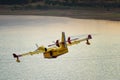 View of fire fighting airplane approaching lake to fill with water.