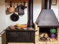 View of a firewood iron stove, a fireplace and some kitchen utensils Royalty Free Stock Photo