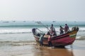 View of fishermen with their boat on the beach in Puri. Royalty Free Stock Photo