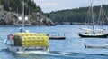 View of Fishing boat full of yellow lobster pots in bay with Porcupine Islnands in background