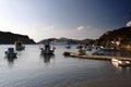 A view of fishing boats and a cruise ship in the beach in the island of Patmos in summer time Royalty Free Stock Photo