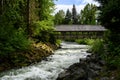 View of Fitzsimmons Creek and a covered wooden bridge over the whitewater river, Whistler, BC, Canada