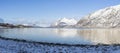 View at the fjord in the Atlantic Ocean with a snowy field in the polar area and mountains covered in snow near Tromso Norway Royalty Free Stock Photo