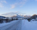 View at the fjord in the Atlantic Ocean with a snowy road in the polar area and mountains covered in snow near Tromso Norway Royalty Free Stock Photo