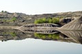 View on a flooded quarry with reflection of hills.