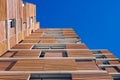 View from the floor of the facade of a modern building clad in ecological wood over clean blue sky, concept of sustainable Royalty Free Stock Photo