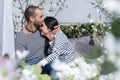 View through flowers on charming international couple kissing an