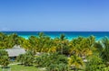 view of a fluffy palm trees tropical garden at the beach, against turquoise azure ocean and blue sky background Royalty Free Stock Photo