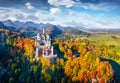 View from flying drone. Gorgeous autumn scene of Neuschwanstein Castle, 19th-century hilltop fairytale castle. Impressive morning