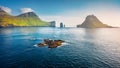 View from flying drone. Misty summer scene of Faroe Islands and Tindholmur cliffs on background. Splendid morning view of Vagar is