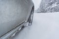 View focused on the car tire during in motion on snowy rural road during snowfall. Royalty Free Stock Photo