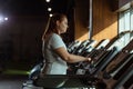 View of focused overweight girl training on treadmill in gym