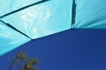 View from foldable sunshield on summer blue sky and beach tree in left corner Royalty Free Stock Photo