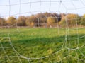 View of football field through hole in goal net Royalty Free Stock Photo