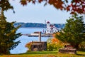 View through forest trees of Maine island housing white home for lighthouse