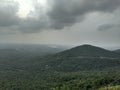 The view of a forest water bodies and green plants and rain bearing clouds in monsoon season from a mountain in indore india. Royalty Free Stock Photo