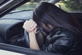 View form front window to a stressed or tired brunette girl in car lying on steering wheel. Female driver resting in vehicle. Royalty Free Stock Photo