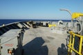 View on forward manoeuvring station on cargo container vessel with black and yellow painted bollards.