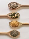 View of four wooden spoons on white background with various types of seeds: sesame, chia, sunflower and pumpkin seeds. Theme for Royalty Free Stock Photo