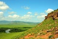 View of a fragment of a rock and a picturesque valley with a bending bed of a beautiful river