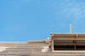 View of the frame of a new wooden roof made of thick beams. Repair of a sloping roof in a country house. Construction site on a Royalty Free Stock Photo