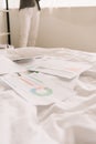 View of freelancer and papers with graphs and charts on white bedding Royalty Free Stock Photo