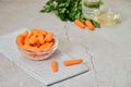 View of fresh baby peeled carrots into glass bowl on stripped napkin Royalty Free Stock Photo