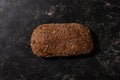 View of fresh baked loaf of whole grain bread on stone black surface Royalty Free Stock Photo