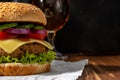 View of fresh tasty burger with glass of beer on wooden rustic table. Food background Royalty Free Stock Photo