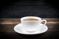 View of a freshly brewed mug of espresso coffee on rustic wooden background with woodgrain texture. Coffee break style, concept Royalty Free Stock Photo