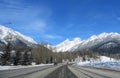 The view through the front of a car driving down the highway through the Rocky Mountains on a sunny, beautiful day Royalty Free Stock Photo