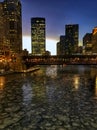 View of frozen Chicago River and as el train passes through during evening rush hour with ice chunks on river. Royalty Free Stock Photo