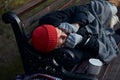 View of frozen old man lying on bench in city park in cold weather Royalty Free Stock Photo