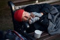 View of frozen old man lying on bench in city park in cold weather Royalty Free Stock Photo