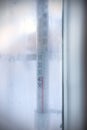 View through frozen window to outdoor thermometer which showing subzero temperature.