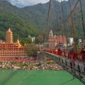 View of Ganga river embankment, Lakshman Jhula bridge and Tera Manzil Temple, Trimbakeshwar in Rishikesh Royalty Free Stock Photo