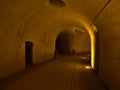 View of gangway in historic castl with paled iron gate and walls illuminated by yellow light in Koblenz, Germany. Royalty Free Stock Photo