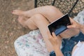 View of the girl from above female legs in the hands of a tablet. Training job blogger shopping online. The concept of remote