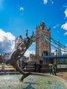 The `Girl with a Dolphin` sculpture and fountain on the waterfront next to Tower Bridge in London, UK on a sunny day.