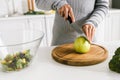 View of girl holding knife near green whole apple Royalty Free Stock Photo