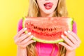 View of girl sticking tongue out and holding watermelon Isolated On yellow Royalty Free Stock Photo