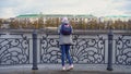 View of girls from back standing on pier. Young woman in warm clothes standing at steel railing of pier. Views of autumn Royalty Free Stock Photo
