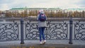 View of girls from back standing on pier. Young woman in warm clothes standing at steel railing of pier. Views of autumn Royalty Free Stock Photo