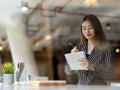 View through glass wall of female office worker writing on schedule book Royalty Free Stock Photo