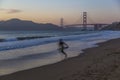 Golden Gate Bridge and surfer from Baker Beach at dusk, South Bay, San Francisco Royalty Free Stock Photo