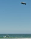 View of Goodyear blimp in the air and lifeguard boat sailing off the coast of Malibu, California.