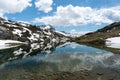 Gorgeous mountain lake in the Alps with reflections and snow remnants Royalty Free Stock Photo