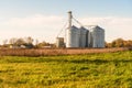 View of a grain elevator in a field at sunset Royalty Free Stock Photo