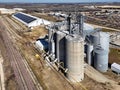 View of grain storage bins from the air with solar powered storage facility in the background Royalty Free Stock Photo